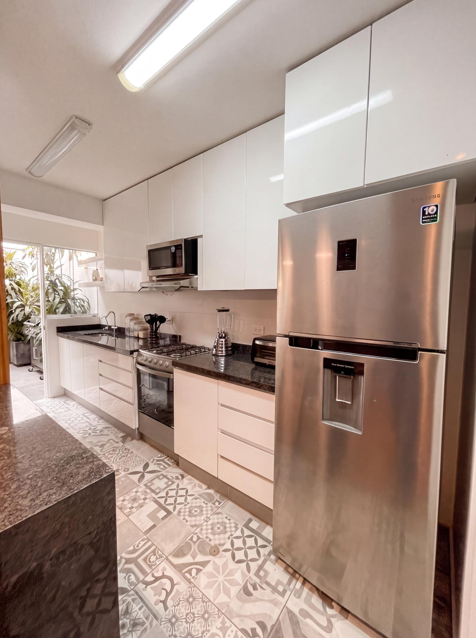 La cocina renovada con barra de granito negro