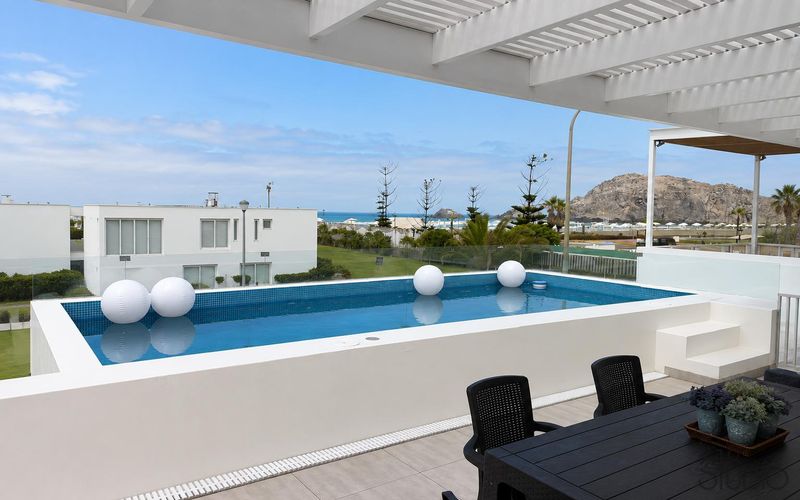 Terraza con piscina y pérgola de la casa de playa en Las Arenas, Asia